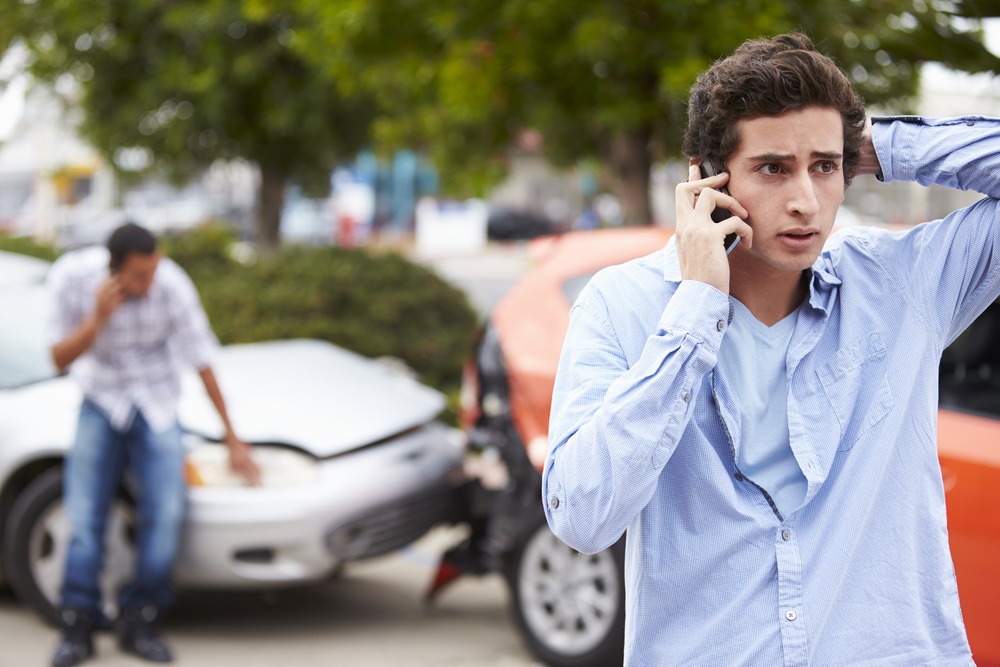 Dos conductores masculinos frenéticamente al teléfono después de un accidente automovilístico Dos conductores masculinos frenéticamente al teléfono después de un accidente automovilístico